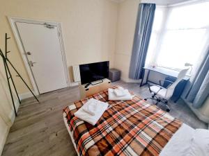 een slaapkamer met een bed met twee handdoeken erop bij Orford Village Room in Londen