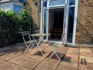 twee stoelen en een tafel voor een deur bij Orford Village Room in Londen