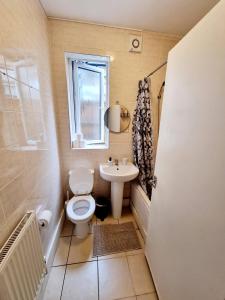 a small bathroom with a toilet and a sink at Orford Village Room in London