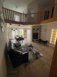 a living room with a leather couch and a table at Maison au sein d’un corps de ferme. 