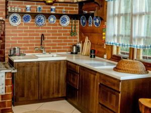uma cozinha com um lavatório e uma parede de tijolos em In The Woods - Chata w lesie na wyłączność em Supraśl