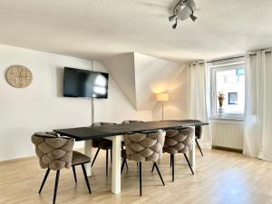 a dining room with a black table and chairs at Apartment über den Dächern Hamelns in Hameln