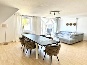 uma sala de estar com uma mesa e cadeiras e um sofá em Apartment über den Dächern Hamelns em Hameln