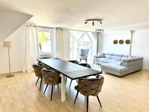 a living room with a table and chairs and a couch at Apartment über den Dächern Hamelns in Hameln