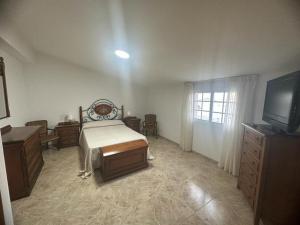 - une chambre avec un lit, une commode et une télévision dans l'établissement O Castro Sanxenxo, à Sanxenxo