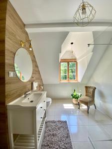 ein Bad mit einem Waschbecken und einem Spiegel in der Unterkunft Zamkowa 4 in Lubniewice