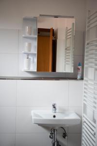 ein weißes Badezimmer mit einem Waschbecken und einem Spiegel in der Unterkunft Appartements Clementina in Premantura