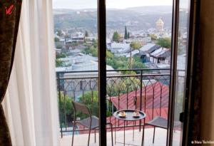 Cette chambre dispose d'un balcon offrant une vue sur la ville. dans l'établissement Sameba Bell, Luxury Apartment, à Tbilissi