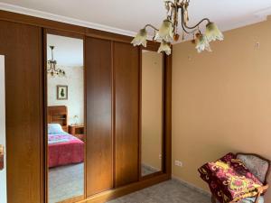 a room with a bedroom with a mirror and a chandelier at Casa Tía María 2 in Villanueva de Arosa