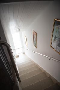eine Treppe in einem Zimmer mit Fenster und Gemälden in der Unterkunft Appartements Clementina in Premantura