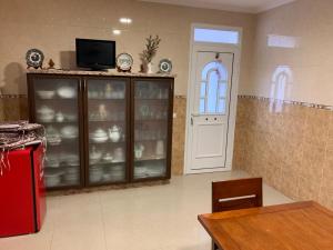 a kitchen with a china cabinet filled with dishes at Casa Tía María 2 in Villanueva de Arosa