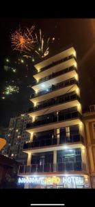 a tall building with fireworks in the sky behind it at HOTEL LORD in Batumi