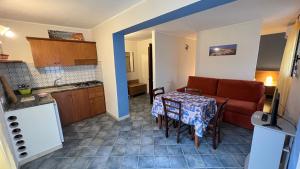 a kitchen and a living room with a table and a couch at Villa Dacla in Lampedusa
