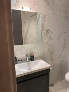 a white bathroom with a sink and a mirror at Κέντρο πόλης Βασίλης 2 in Ioannina