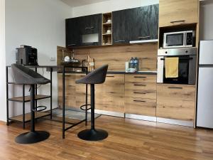 a kitchen with a counter and two bar stools at EGGO APARTMENT - Oasis Beach Apartments Kamchia in Dolen Bliznak