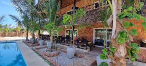 uma casa com piscina e palmeiras em Salama & Mbuyuni Bungalows em Matemwe
