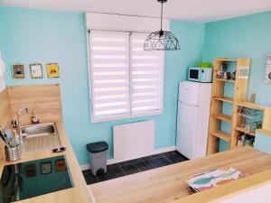 a kitchen with a sink and a refrigerator at Maison proche du bourg de Crozon et des plages de Morgat in Crozon