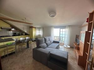 a living room with a couch and a kitchen at O Castro Sanxenxo in Sanxenxo