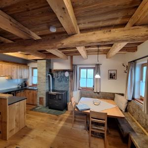 a kitchen and dining room with a table and a stove at Almchalet Schuster in Diex