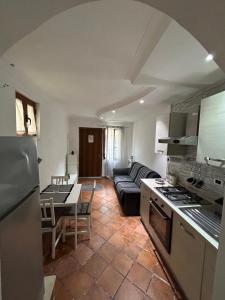 eine Küche und ein Wohnzimmer mit einem Sofa und einem Tisch in der Unterkunft Sun Garden Home in Somma Vesuviana