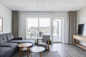 a living room with a couch and a tv at Hotell Hamnen in Färjestaden