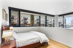 a bedroom with a bed and large windows at Airy and Open Corner Loft - 92 Walkscore in Redmond