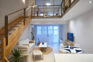 a living room with a staircase and a couch at Seagull Luxury Maisonette in Itea