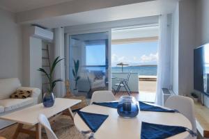 uma sala de estar com mesa e cadeiras e o oceano em Seagull Luxury Maisonette em Itea