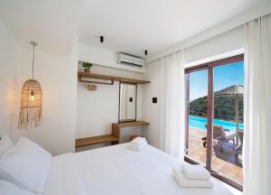 um quarto com uma cama e vista para uma piscina em Anemones Villas by Omikron Selections em Spanokhórion