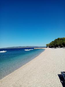 a sandy beach with two boats in the water at Apartment Hortenzija in Baška Voda