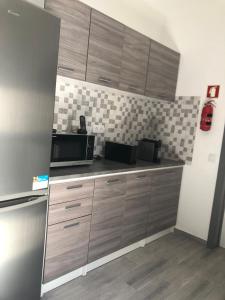 a kitchen with wooden cabinets and a microwave at Casa Da Praça in São Pedro do Corval