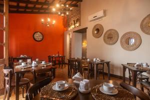a restaurant with wooden tables and chairs and a clock on the wall at Hotel Boutique Balcón de la Plaza in Salta