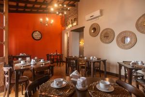 サルタにあるHotel Boutique Balcón de la Plazaの木製のテーブルと椅子、壁掛け時計のあるレストラン