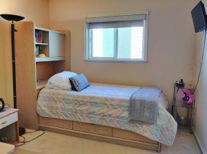 a small bedroom with a bed and a window at Helen's House / Close to Skytrain and Airport in Vancouver