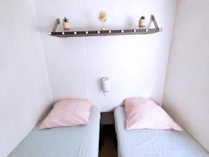 2 camas en una habitación pequeña con plantas en el estante en Domaine des Iscles en La Roque-dʼAnthéron