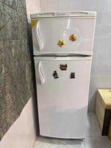 um frigorífico branco com ímanes numa cozinha em Turtle house em Dahab