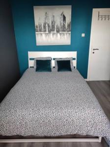 - une chambre avec un grand lit aux murs bleus dans l'établissement Escale, à Liège
