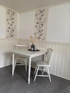 a white table and two chairs in a room at Overnatting på Leknes in Leknes