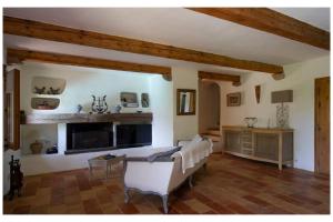 a living room with a white couch and a fireplace at Les Lauriers Roses Palombaggia Porto-Vecchio in Porto-Vecchio