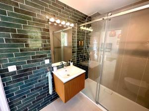La salle de bains est pourvue d'un lavabo et d'une douche. dans l'établissement Paisible studio tout neuf en lisière de forêt, à Peyrolles-en-Provence