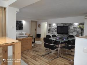 een woonkamer met een tafel en stoelen en een bank bij Suite4you in Pirovac