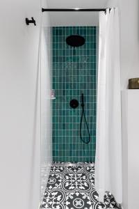 een badkamer met een douche en een groene muur bij Fresh unit, high quality design. in Tallinn