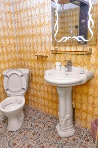 a bathroom with a toilet and a sink at NAIVELI-PALM Appartement meublé sobre et chic in Douala