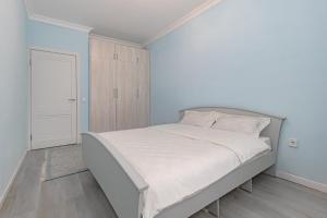 een witte slaapkamer met een bed en een kast bij Korkem 4-313 Триумфальная Арка in Taldykolʼ +19 foto's