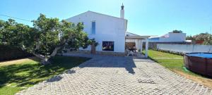 a white house with a tree in the yard at Casa do Tonel in Sagres