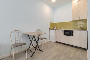 een keuken met 2 stoelen en een tafel. bij Korkem 4-313 Триумфальная Арка in Taldykolʼ