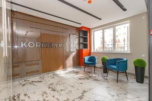 een lobby met twee blauwe stoelen en een bord aan de muur bij Korkem 4-313 Триумфальная Арка in Taldykolʼ