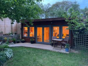 a small cabin with a table and chairs on a patio at The Bee Hive Garden Room in Dorchester