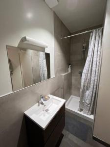 a bathroom with a sink and a mirror and a tub at Une nuance de fantaisie in Angoulême
