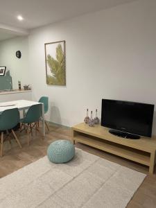un soggiorno con TV a schermo piatto e tavolo di Casa dos Arcos a Vila do Conde